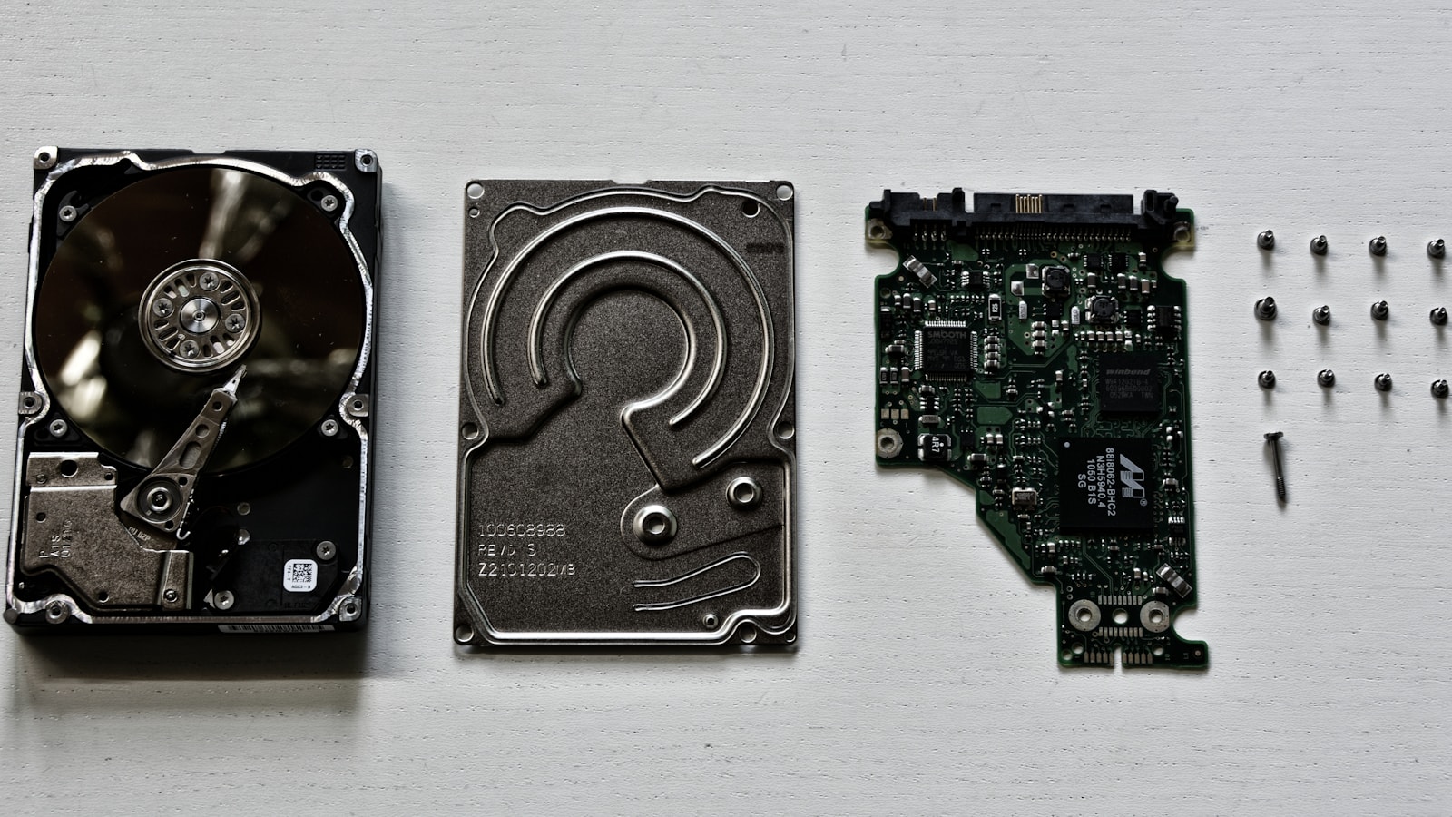 Disassembled computer hard drive components arranged on a work surface